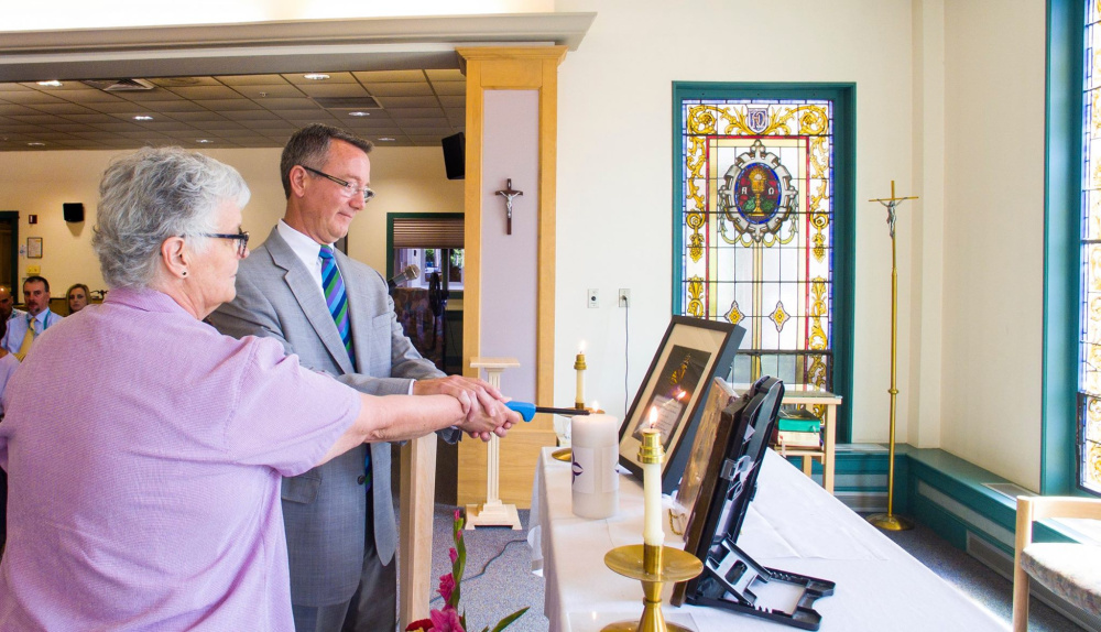 Sister Gilla Dube, provincial of the Sisters of Saint Joseph of Lyon, and William J. Fiocchetta, president and CEO of The Mercy Community, light a unity candle Aug. 2 during the Unification Celebration held at Mount Saint Joseph Residence and Rehabilitation in Waterville.