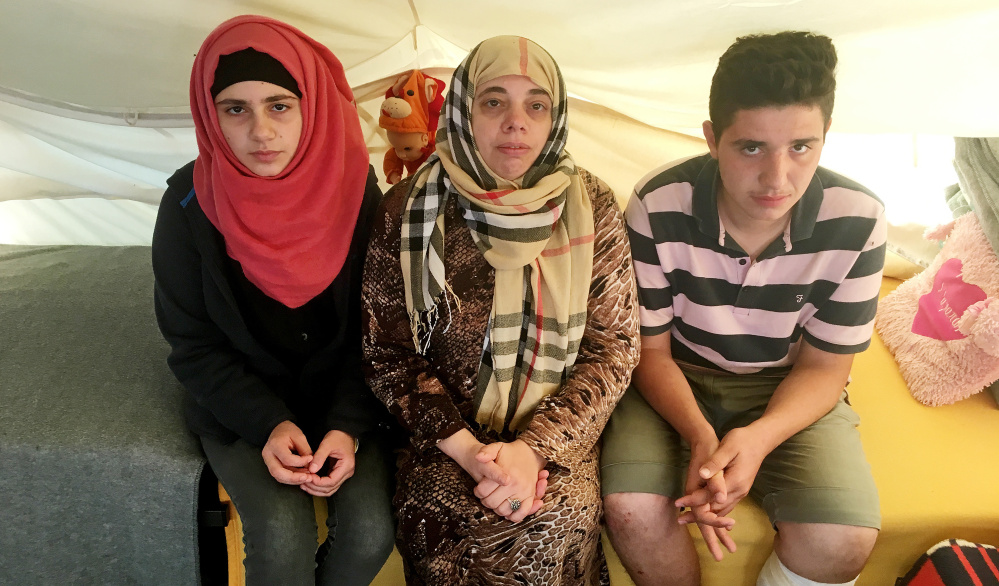 Lamis Wahed, center, sits with two of her four children, Rama, 16, left, and Kamal, 17. Stranded in Greece for seven months, they have applied for a program to resettle them elsewhere in Europe. But EU nations are reneging on their promises.