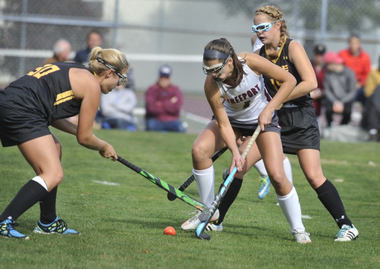 Freeport's Chloe Davidson battles for the ball with Ellie Garfield, left, and Erika Miller of Cape Elizabeth during Saturday's game. Freeport won the Class B South field hockey prelim, 3-0.