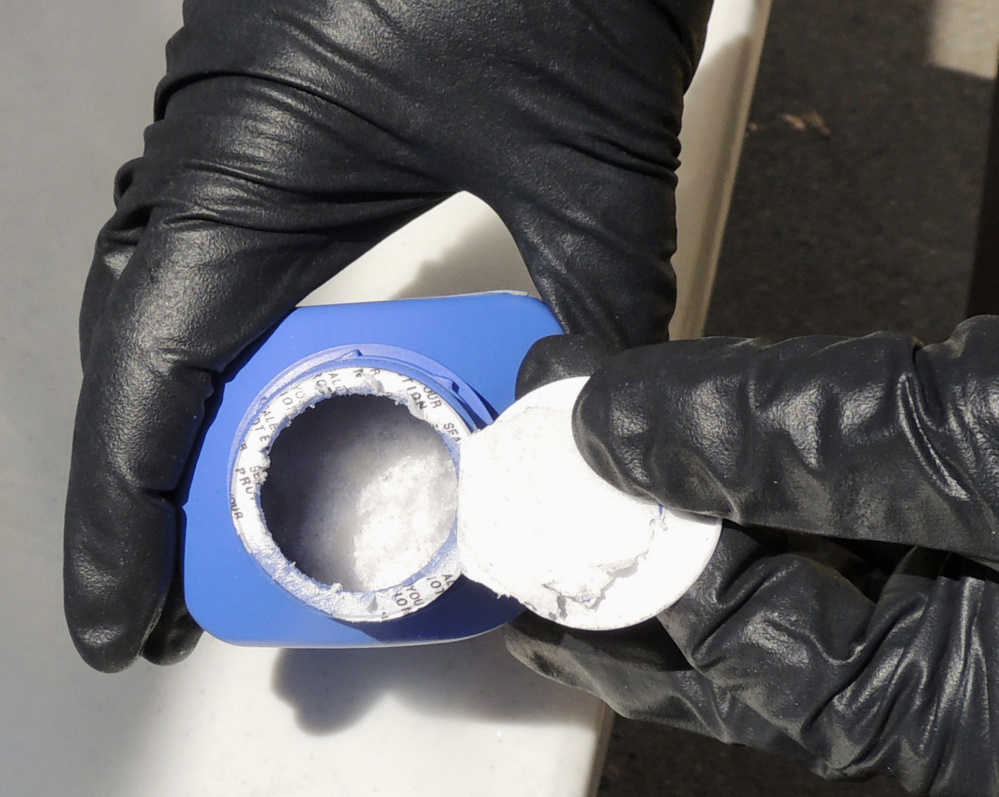 A member of the Royal Canadian Mounted Police opens a printer ink bottle containing the opioid carfentanil imported from China.
Royal Canadian Mounted Police via AP