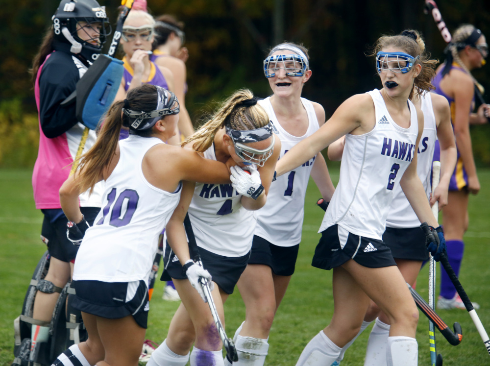 Marshwood High's Elaine Bachelder, left, Hannah Costin and Leah Glidden, right, celebrate a goal by Celine Lawrence in the second half of the Hawks' 4-1 victory over Cheverus in a Class A South field hockey quarterfinal on Tuesday in South Berwick. (Photo by Derek Davis/Staff Photographer)