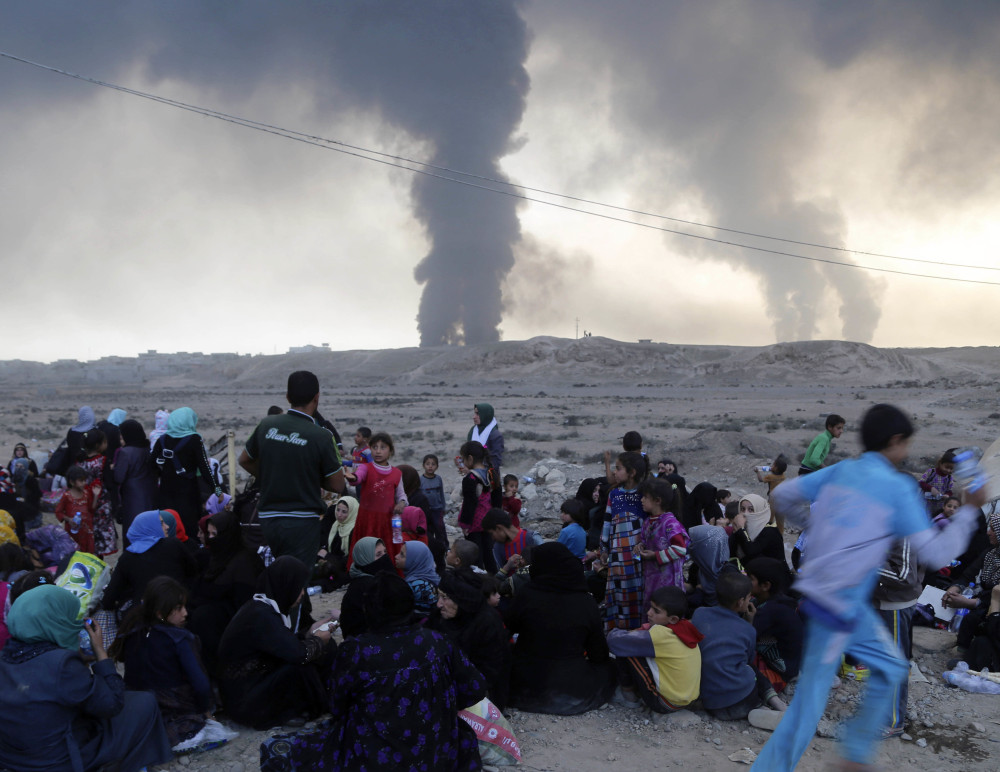 Smoke rises as people flee their homes during clashes between Iraqi and Islamic State forces near Mosul, Iraq, on Tuesday. Capturing the city represents a critical showdown for the Iraqis.