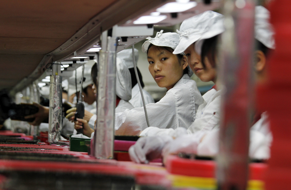 Workers for the global electronics manufacturer Foxconn, Apple's main supplier of iPhones, are seen inside a factory in Longhua, China, in 2010. Making iPhones in the United States would add $50 to $100 to the cost of each one.