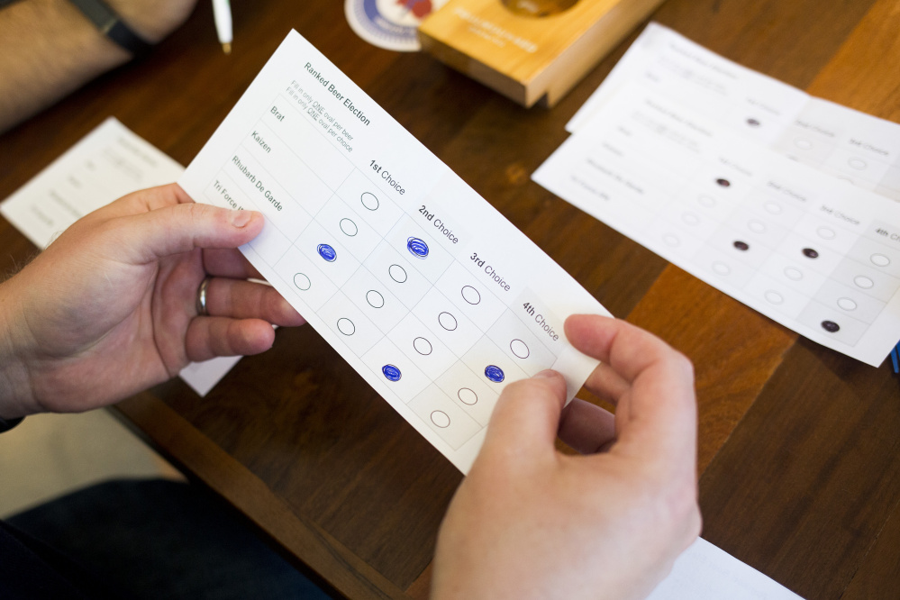 In this October 2016 file photograph, sample ballots  are counted in a demonstration of how ranked-choice voting would work.