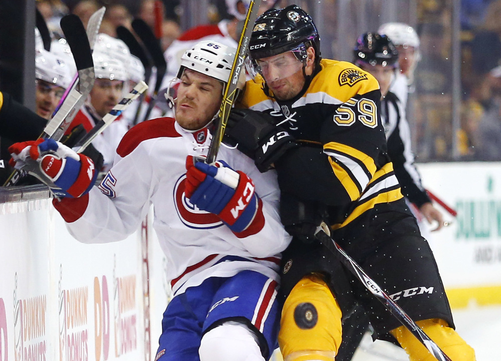 Montreal's Andrew Shaw is checked into the boards by Tim Schaller of the Bruins during Saturday's game at TD Garden. The Canadiens improved to 4-0-1 with a 4-2 win.