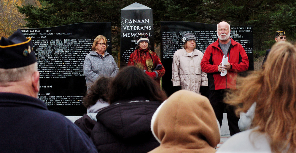 Veterans committee member Dale Burrill, in red jacket, speaks Sunday during the memorial dedication in Canaan. 