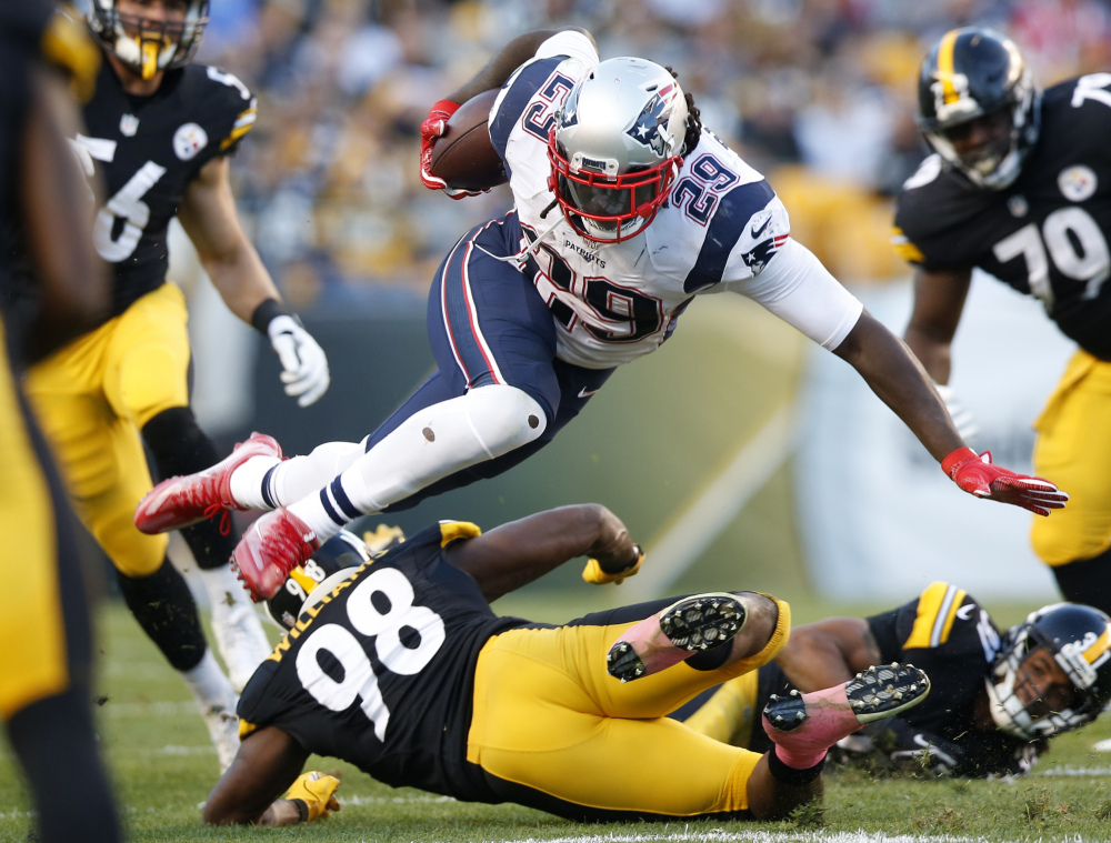 New England Patriots running back LeGarrette Blount is upended by Steelers inside linebacker Vince Williams during the first half in Pittsburgh on Sunday.