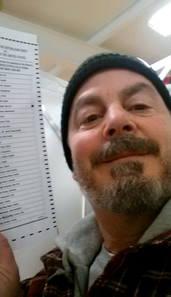 Bill Phillips of Nashua, N.H., takes a selfie with his marked ballot during the New Hampshire primary election last February.