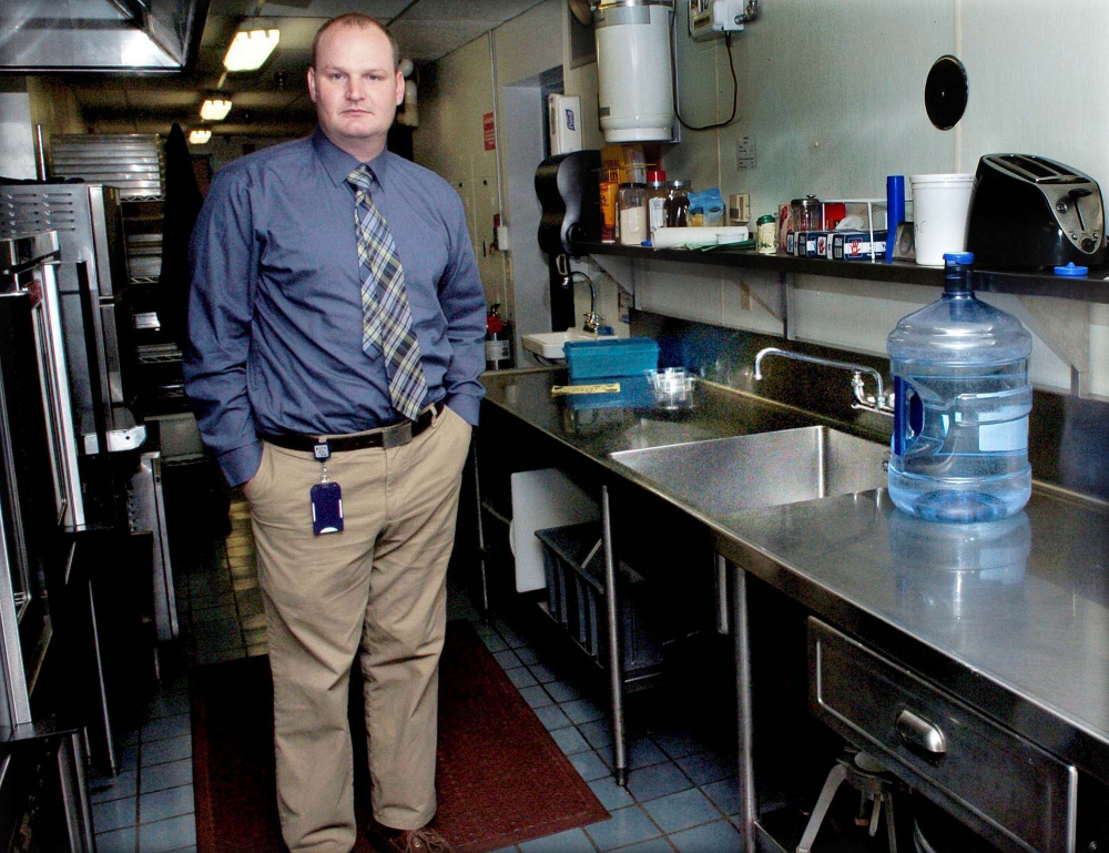 Benton Elementary School Principal Brian Wedge stands beside the school cafeteria kitchen sink on Tuesday, where exceptionally high levels of lead were detected in October, but further testing has revealed lower levels.