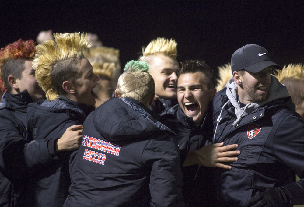 Scarborough players and coaches celebrate after the Red Storm scored late in the second half of their 1-0 victory over South Portland on Tuesday night at Scarborough High. (Photo by Brianna Soukup/Staff Photographer)