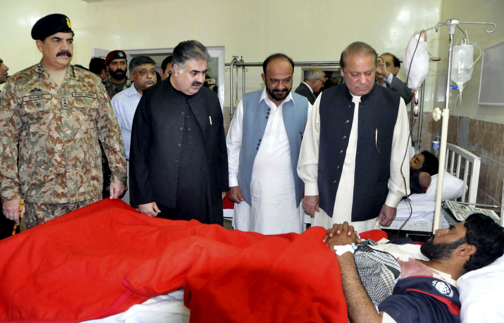 Pakistan's Prime Minister Nawaz Sharif, right, talks to a survivor of an overnight attack on the Police Training College, with army chief Gen. Raheel Sharif, left, at a hospital in Quetta on Tuesday. 
Associated Press