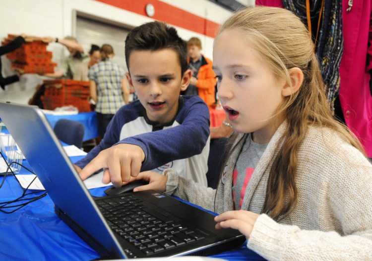 Adam Metcalf, left, and Amelia Jackson, fourth-graders from Adams School in Castine, enter vote tallies into a laptop during the Secretary of State Office's Student Mock Election event Wednesday at the Augusta Armory.