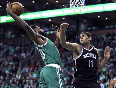 Boston's Amir Johnson, left, grabs a rebound over Brooklyn's Brook Lopez in the first quarter of Wednesday's opener at Boston.