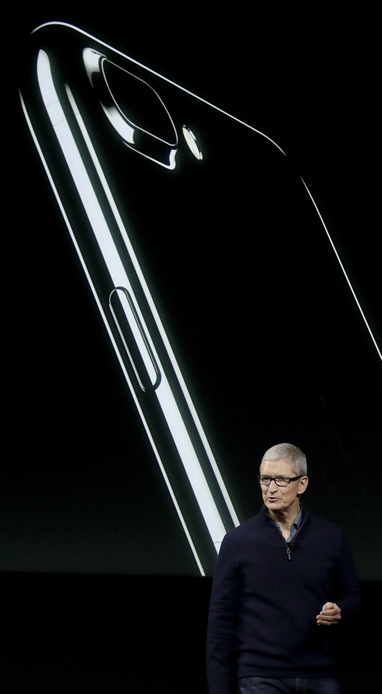 Apple CEO Tim Cook discusses the iPhone, depicted behind him, during an announcement of new products Thursday in Cupertino, Calif.