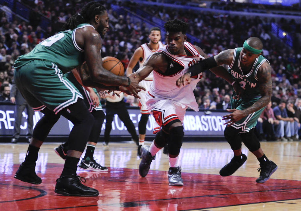 Jimmy Butler of the Bulls, center, battles for a ball with Boston's Jae Crowder, left, and Isaiah Thomas in the second quarter of Thursday's game at Chicago.