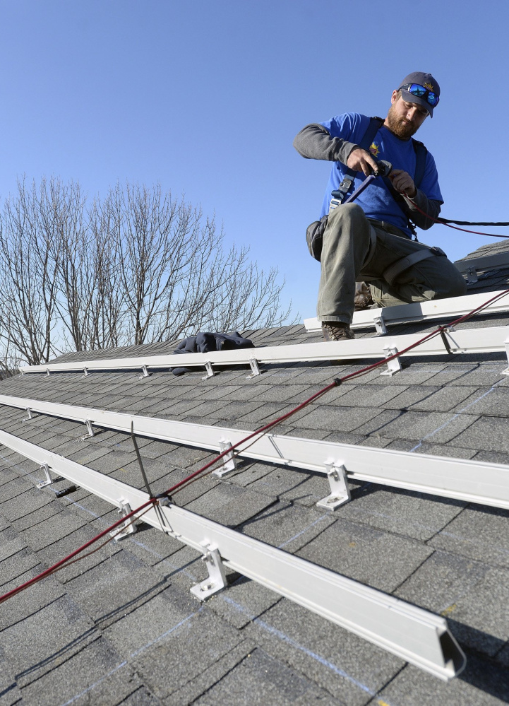 Zach Good of ReVision Energy prepares a roof for solar panels at a home on Overlook Lane in Cape Elizabeth in 2015.