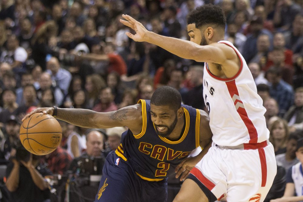 Cleveland's Kyrie Irving, left, drives on Toronto's Cory Joseph during the second half of a 94-91 win by the Cavaliers at Toronto on Friday. Irving led the Cavaliers with 26 points.