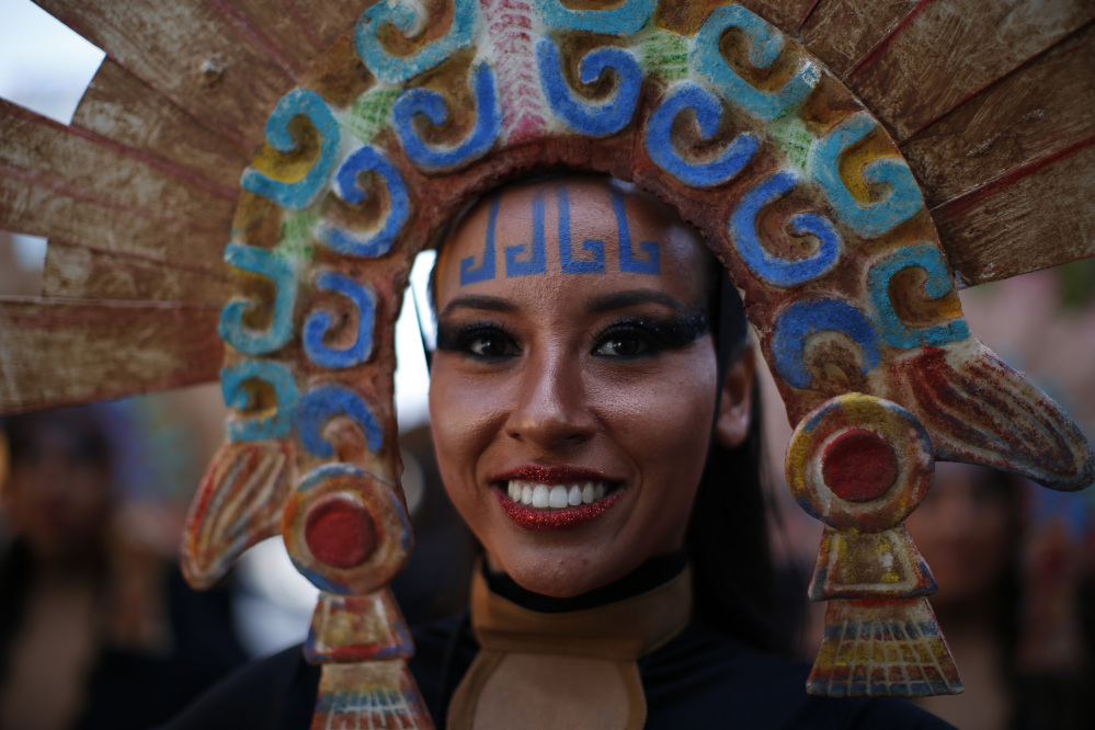 A woman in costume smiles as she waits for the start of a Day of the Dead parade to begin in Mexico City on Saturday
(AP Photo/Dario Lopez-Mills)