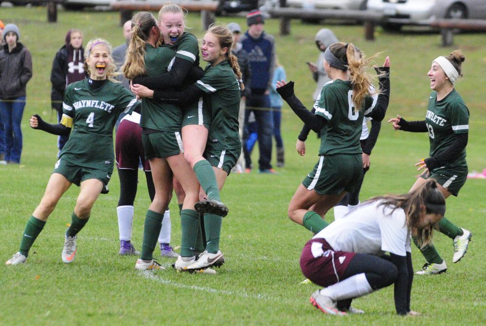 Lydia Giguere gets a hug from one of her teammates after scoring in overtime to give Waynflete a 2-1 win over Monmouth Academy in a Class C South girls' soccer semifinal Saturday.