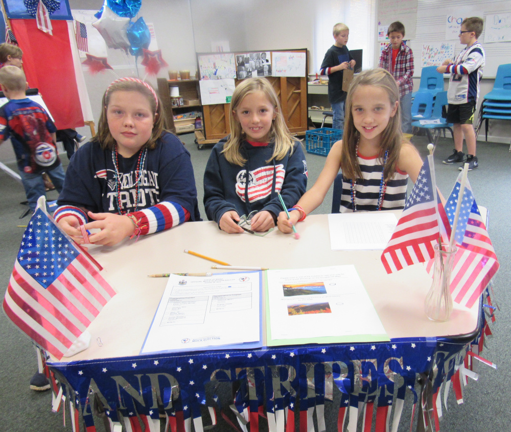 Sebago Elementary School students, from left, Emma McKenney, Averie Smith and Madyson Lantz man a voter registration table during a recent mock election at the school. All three are in the fourth grade. Students in third through fifth grades helped in the voter education process, performing skits for kindergarten through second grade  students, helping teach about the election and the process of voting. Later, the students voted on the candidates for president and the Senate.