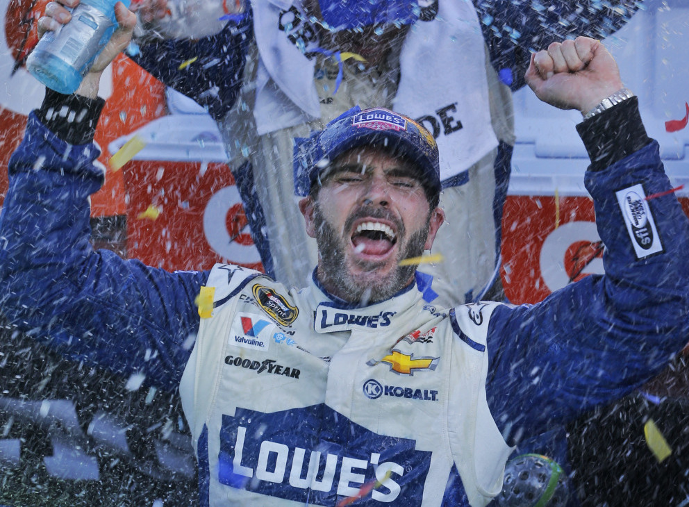 Jimmie Johnson celebrates his victory Sunday at Martinsville Speedway that assured him of a chance to race for a seventh Sprint Cup championship in the season finale.