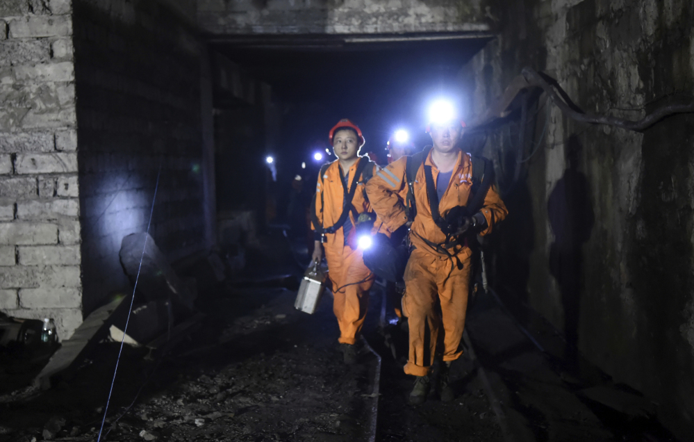 Rescuers work Monday at the Jinshangou Coal Mine in Chongqing, southwest China, where a gas explosion killed more than a dozen workers. Hundreds of rescuers were hindered by debris as they worked through the night trying to find another 20 miners.