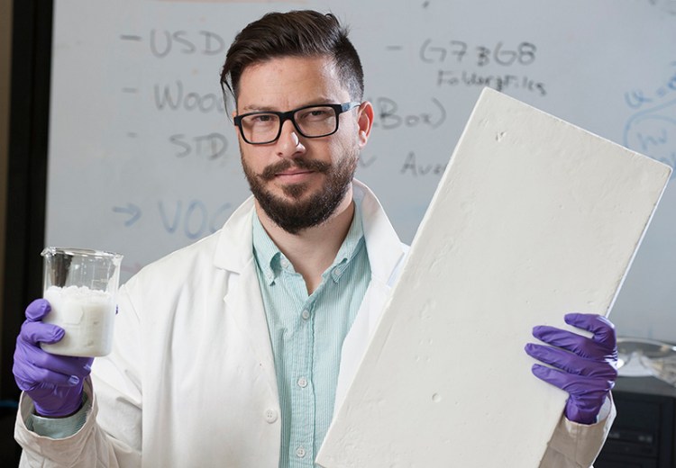 Nadir Yildirim holds a wood and water slurry in one hand and a sample insulation board made from the slurry in the other at his lab at the University of Maine.
