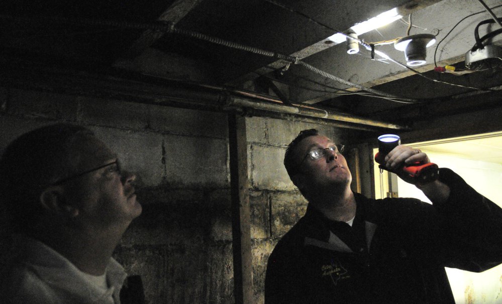 City of Augusta Code Enforcement Officer Robert Overton and Deputy Fire Chief David Groder look at wiring during an inspection on Oct. 2 of an apartment building.