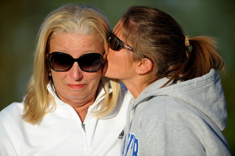 Paula Doughty, left, head coach of the Skowhegan Area High School field hockey team, becomes emotional as she receives a kiss following her 500th victory as head coach.       Michael G. Seamans/Morning Sentinel