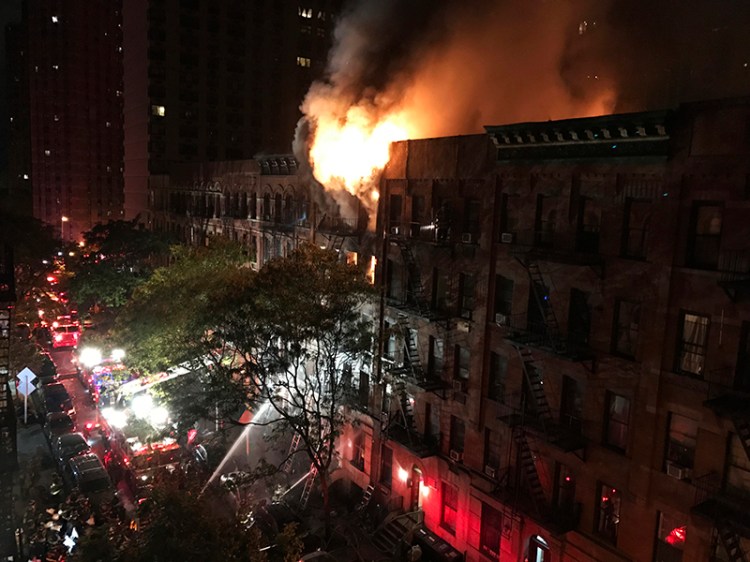 Firefighters work to put out a blaze at an apartment building on the Upper East Side in New York early Thursday.