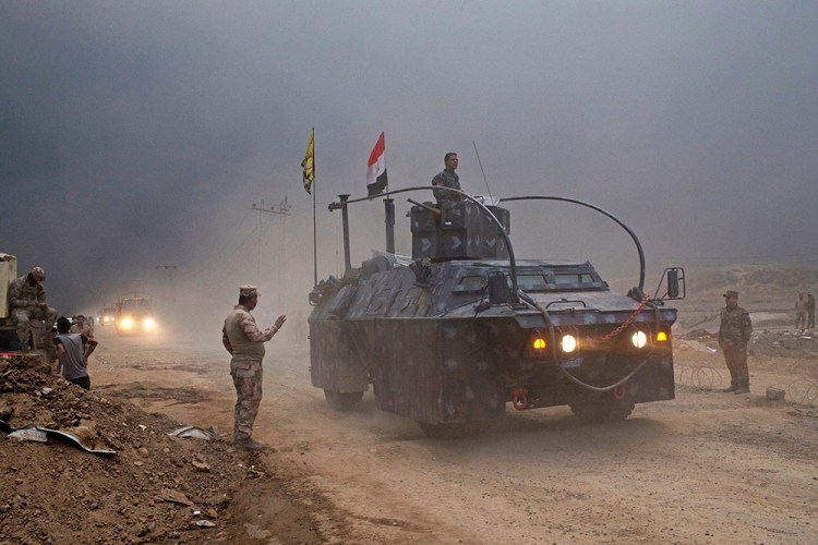 An Iraqi Federal Police vehicle passes through a checkpoint in Qayara, about 30 miles south of Mosul, Iraq, Wednesday, Islamic State militants have been going door to door in farming communities south of Mosul, ordering people at gunpoint to follow them north into the city. <em>Associated Press/Marko Drobnjakovic</em>