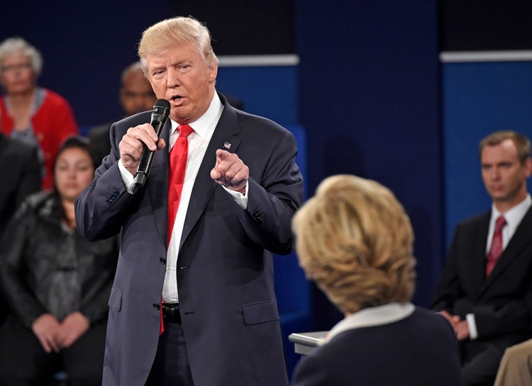 Republican presidential nominee Donald Trump points at Democratic nominee Hillary Clinton as he speaks during the second presidential debate, in St. Louis, Sunday. His "jail" line was one of the most-discussed debate moments on social media during the debate.<em>Saul Loeb/Pool via AP</em>