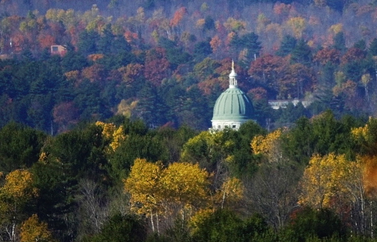 Fall foliage dots Howard Hill rising behind the State House from Route 17 in Augusta. The Land for Maine's Future Board voted Tuesday to reduce the state's contribution toward purchasing the 164-acre tract for public use.