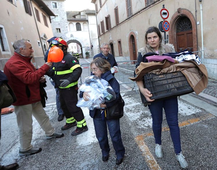 Residents carry some of their belongings in the small town of Visso in central Italy Thursday, after a 5.9-magnitude earthquake destroyed part of the town. A pair of strong aftershocks shook central Italy late Wednesday, crumbling churches and buildings, knocking out power and sending panicked residents into the rain-drenched streets just two months after a powerful earthquake killed nearly 300 people. <em>Associated Press/Alessandra Tarantino</em>