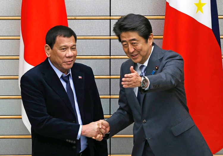 Philippine President Rodrigo Duterte, left, is greeted by Japan's Prime Minister Shinzo Abe at the start of their meeting in Tokyo Wednesday <em>Associated Press/ssei Kato via Associated Press</em>