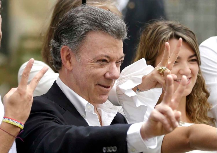 Colombia's President Juan Manuel Santos makes the victory sign Sunday after voting in a referendum to decide whether or not to support the peace deal he signed with rebels of the Revolutionary Armed Forces of Colombia, FARC, in Bogota, Colombia. <em>Ricardo Mazalan/Associated Press</em>