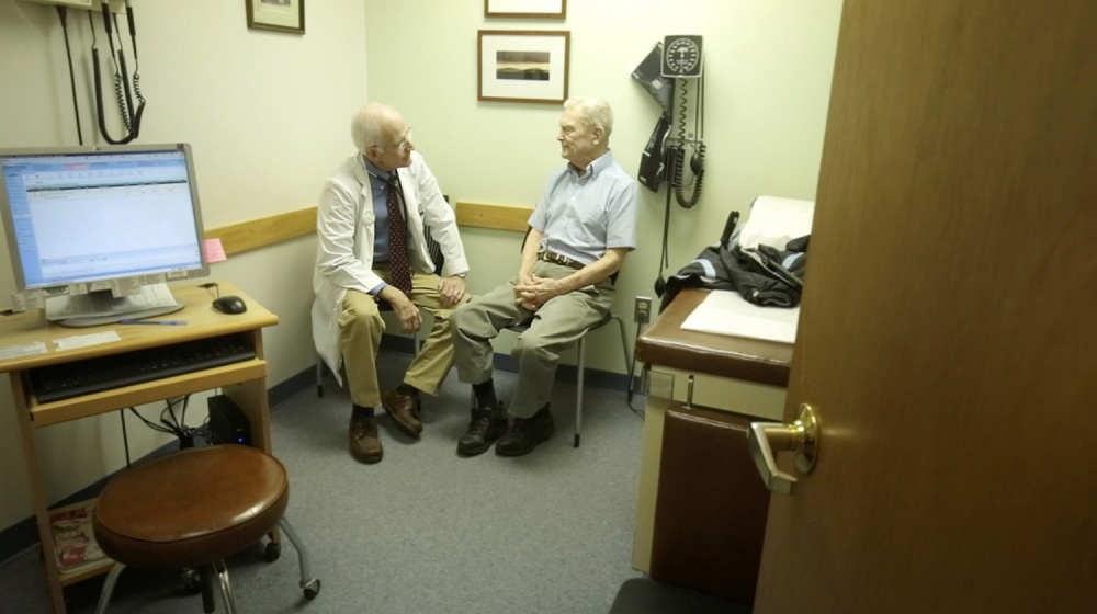 Dr. William Medd talks with patient Frank Floster at Medd's primary care practice in Norway in 2014. Now 73, Medd is still practicing medicine, but he worries about who will take his place when he retires, he has told the Press Herald – and the approval of Question 2 would make it even harder to encourage young doctors to come to Maine.
