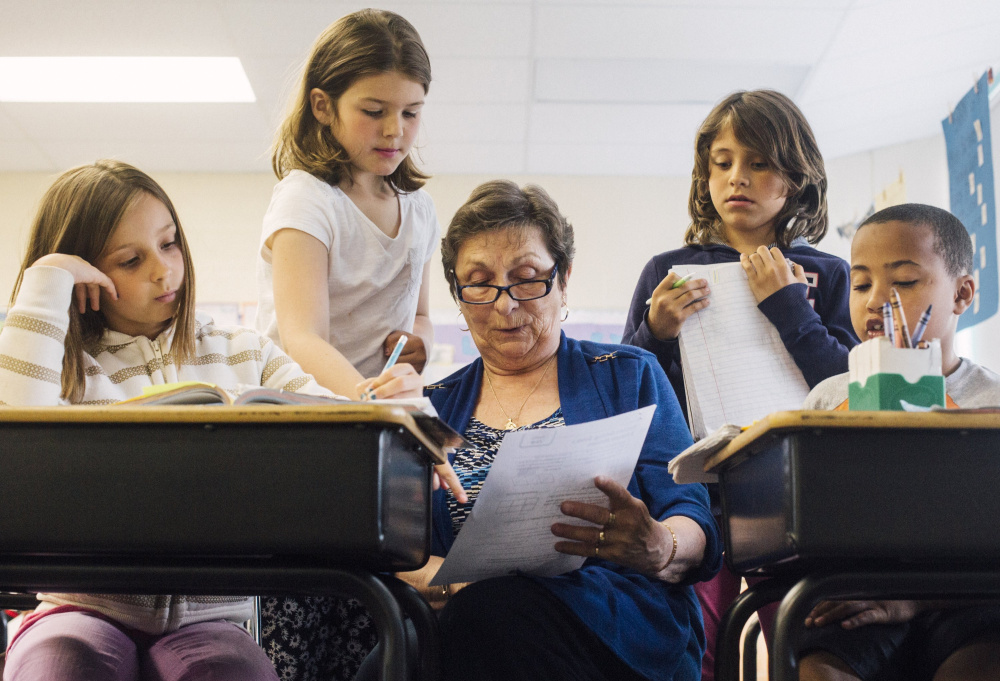 Third-graders Alexus Chapman, Charlotte Libby, Lucy Tidd and Donald Enman get help with their math assignments from Foster Grandparent Fran Seeley at Portland's Lyseth School in 2015. If Question 2 passes, Portland stands to receive about $11 million in additional state aid.
