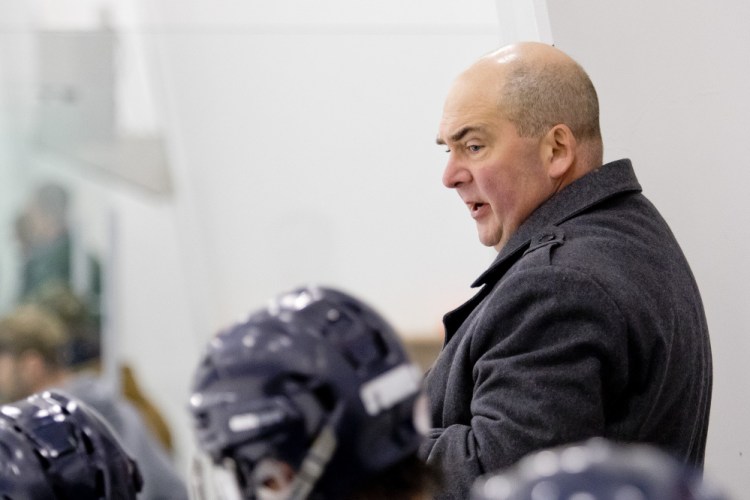 Jeffrey Beaney, coaching the Portland/Deering high school hockey team, speaks with his players during a game in December 2015. Beaney was USM's coach for nearly three decades.
