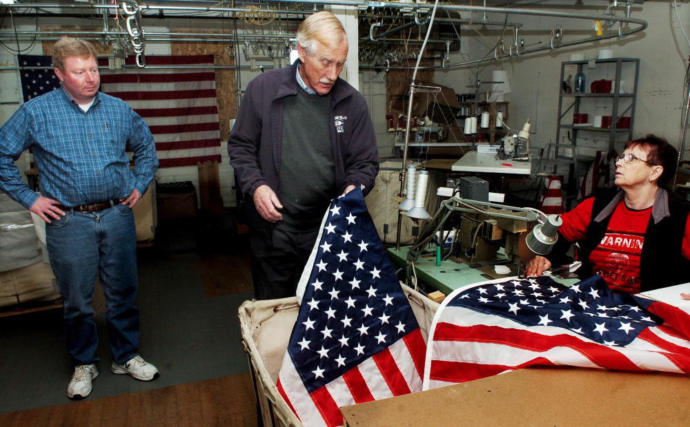 U.S. Sen. Angus King, I-Maine, examines an American flag sewn by Maine Stitching Specialties employee Charlene Goodrich as owner Bill Swain conducts a tour of the Skowhegan company on Tuesday.