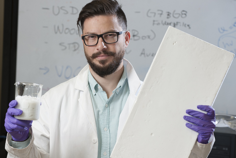 Nadir Yildirim holds a wood and water slurry and a sample insulation board made from the slurry at his University of Maine lab. The work he's doing shows how homegrown innovation can draw wealth to Maine.