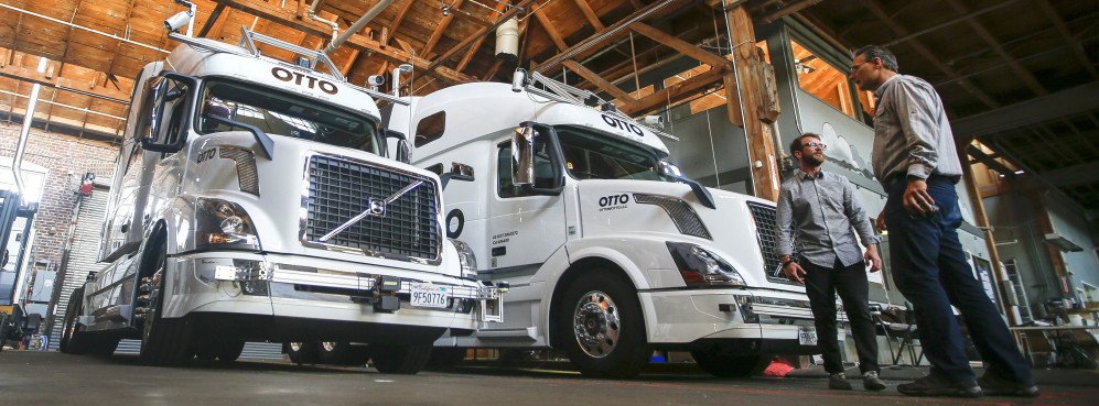 Employees stand next to self-driving, big-rig trucks during a demonstration at the Otto headquarters in San Francisco. Uber's self-driving startup Otto developed technology allowing big rigs to drive themselves. Robots could be coming for a new class of worker: people who drive for a living.