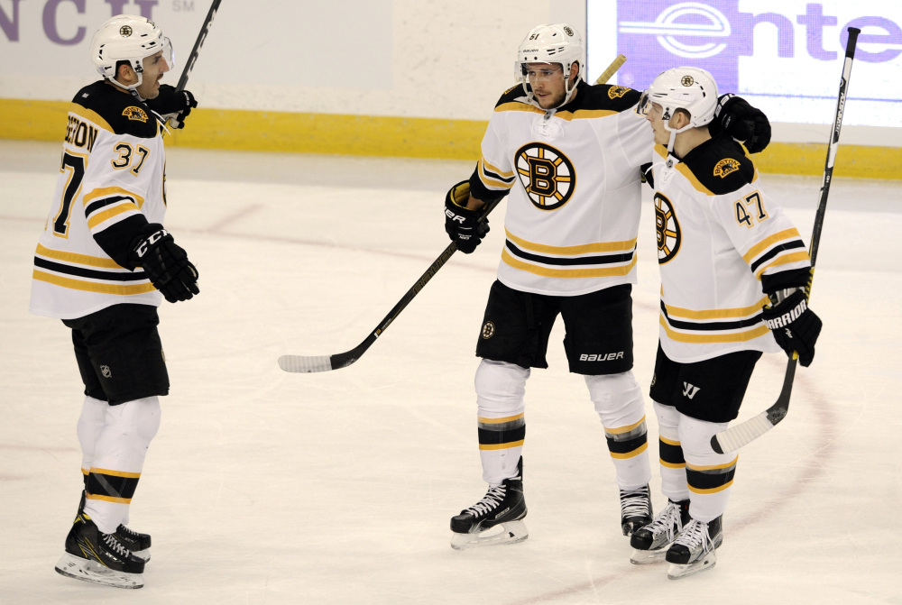 Boston's Patrice Bergeron, 37, and Torey Krug, 47, celebrate with Ryan Spooner after Spooner's goal against the Tampa Bay Lightning in the first period Thursday night in Tampa, Fla.
