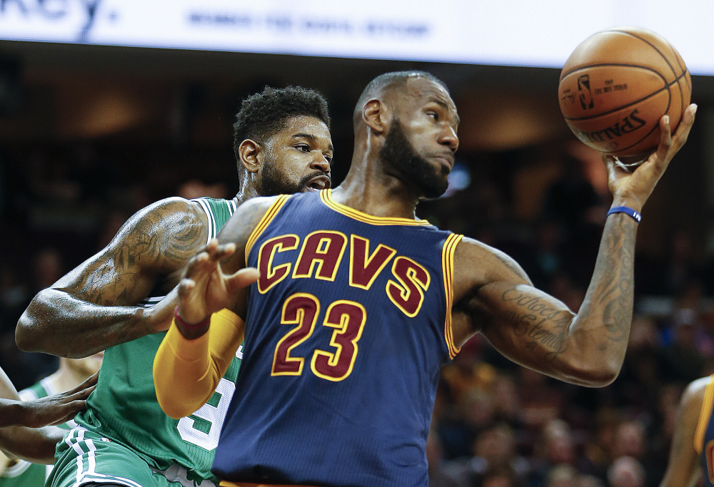 LeBron James grabs a rebound against Boston's Amir Johnson in the first half Thursday night in Cleveland.