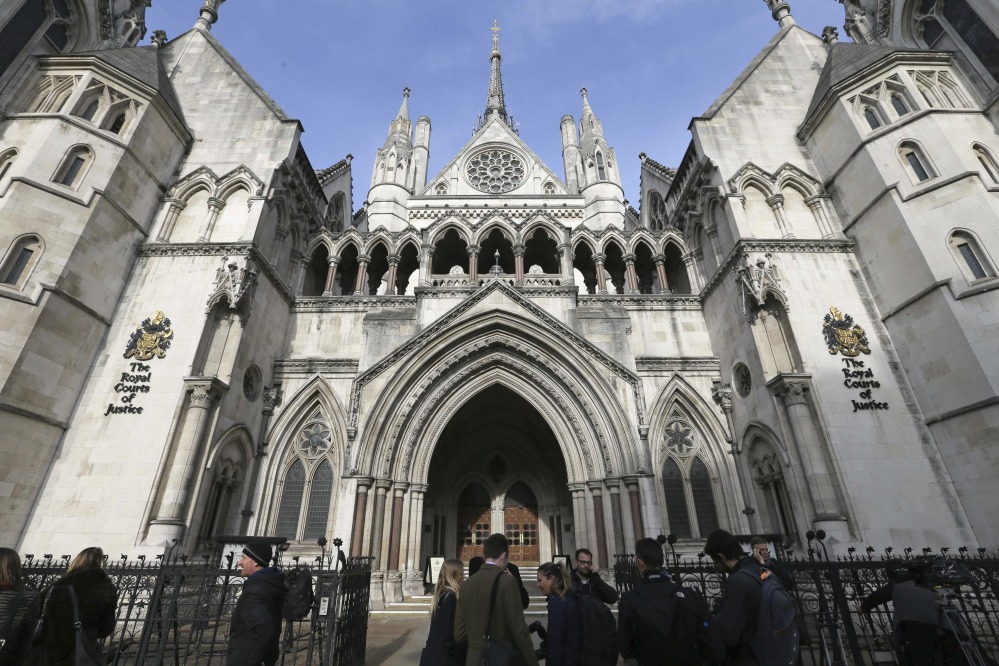 Media gather outside the High Court in London, Thursday Nov. 3, 2016 as they wait for the decision on the challenge to plans for Brexit. In a major blow for Britain's government, the High Court ruled Thursday that the prime minister can't trigger the U.K.'s exit from the European Union without approval from Parliament. (AP Photo/Tim Ireland)