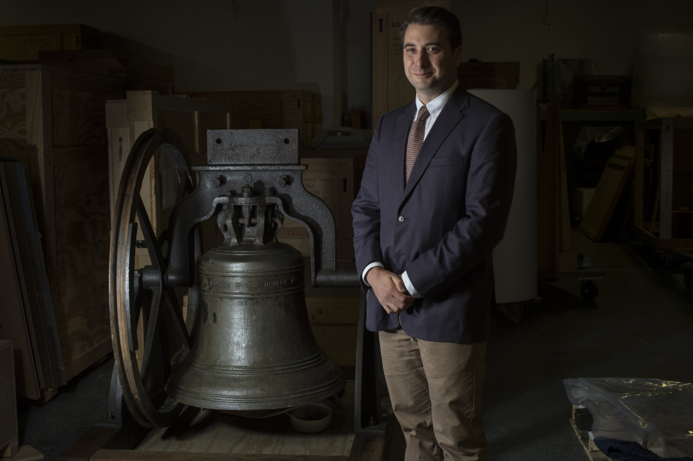 Religion curator Peter Manseau poses for a portrait near a church bell made by Paul Revere at the Smithsonian National Museum of American History in Washington.