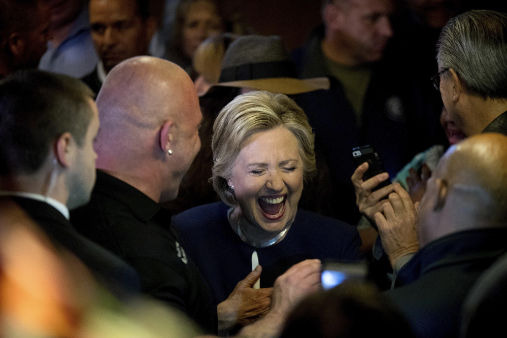 Democratic presidential candidate Hillary Clinton laughs while talking with patrons at Miller's Bar in Dearborn, Mich., on Friday.