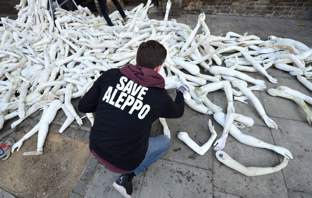 An activist places false limbs outside the Russian Embassy in London where two campaign groups, The Syria Campaign and Syria Solidarity UK, have scattered over 800 limbs to protest at the bombing of civilians in Aleppo, Syria.