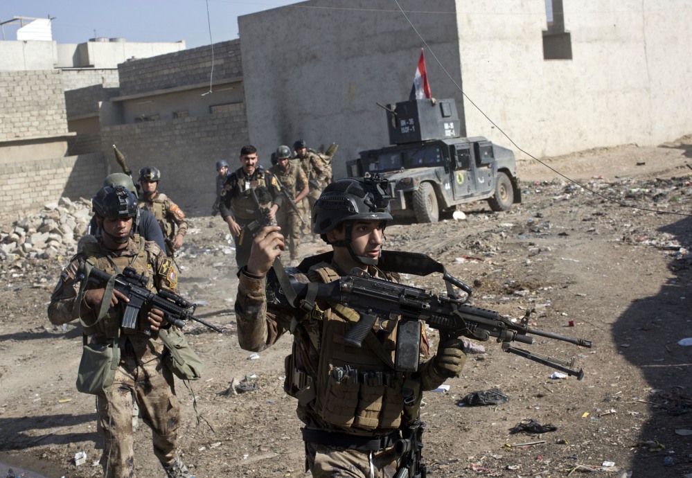 Iraqi special forces soldiers move in formation in an alley on the outskirts of Mosul, Iraq, on Friday. A two-pronged assault against Islamic State militants involved more than 3,000 Iraqi troops and unleashed intense street battles. At one point, seven suicide attackers barreled in vehicles laden with explosives toward the troops.