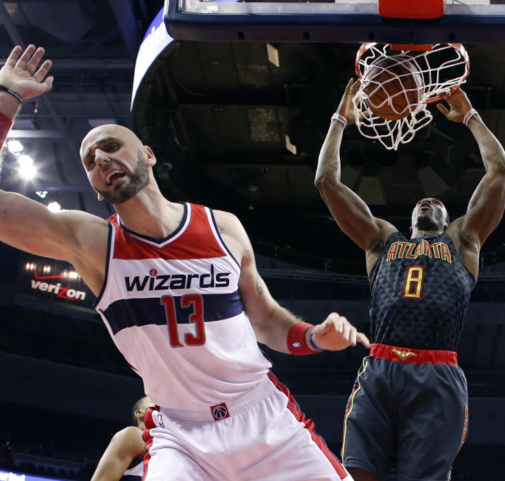 Wizards center Marcin Gortat can't stop a dunk from Hawks center Dwight Howard during the first half of their game in Washington on Friday. The Wizards won 95-92.